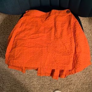 Mini skirt; orange ; button on the front; brand new with tags; xs